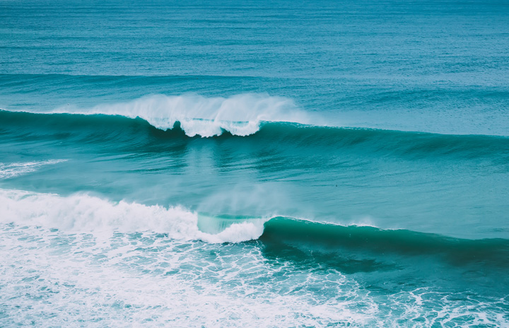 Calm looking ocean with two small waves.